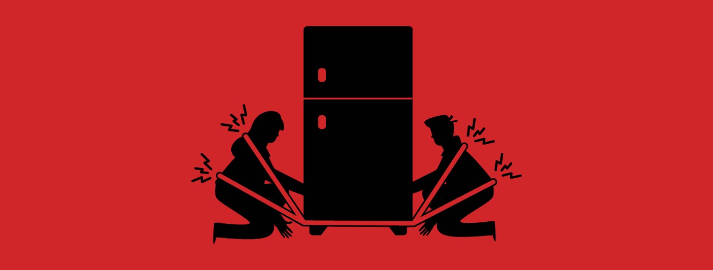 two people using shoulder dolly straps to lift a fridge